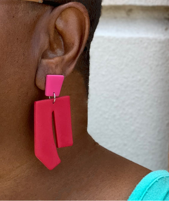Model wearing red/pink earrings.